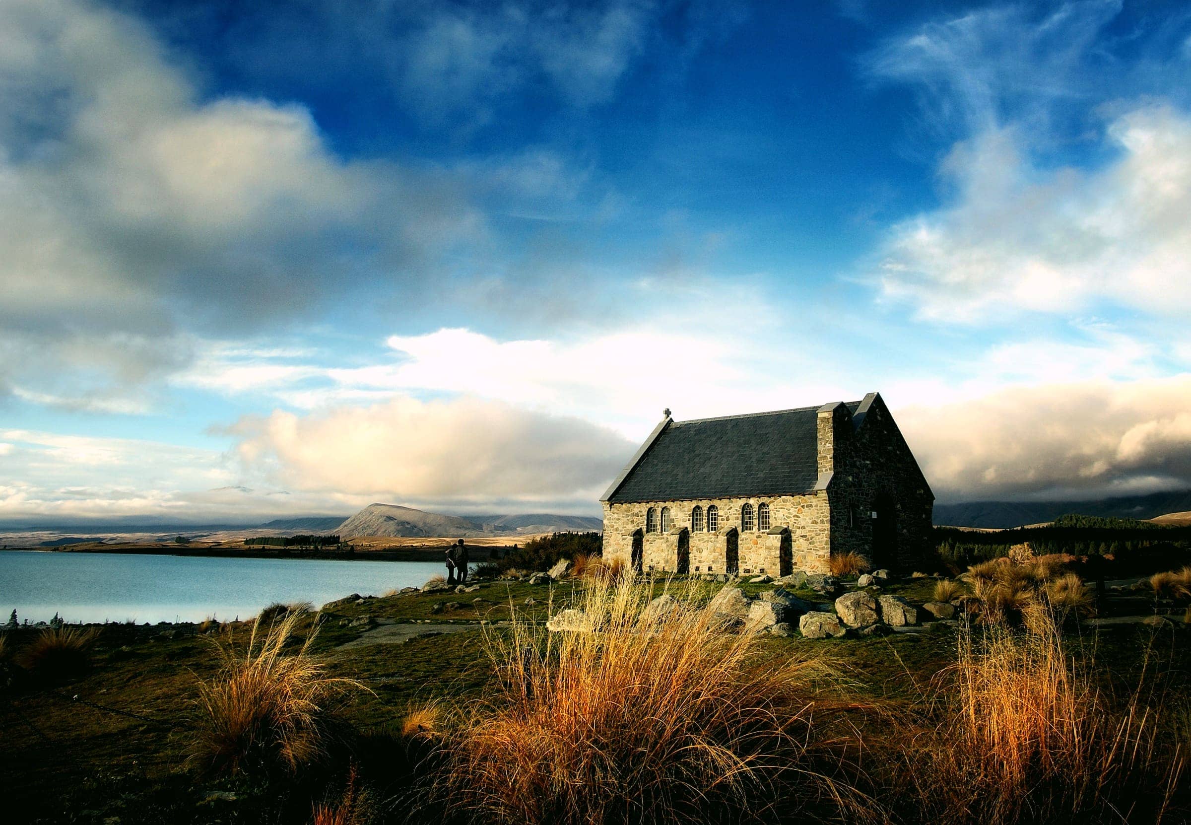 The stone Church of the Good Shepherd on the shore of Lake Tekapo under a dramatic sky